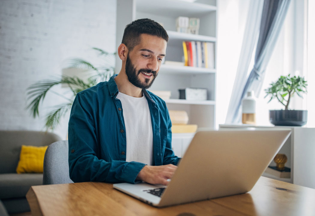man using a laptop at a living room table