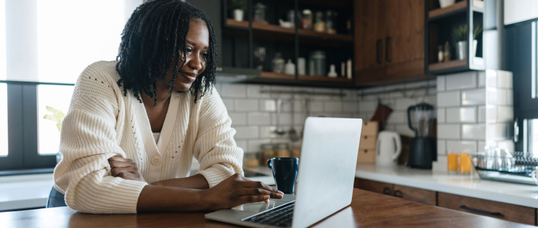 woman using a laptop in a modern kitchen