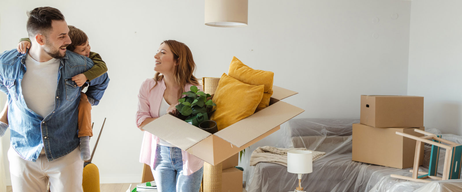 young family unpacking moving boxes